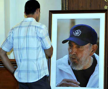 Un hombre mira la foto de Fidel hecha por Alex